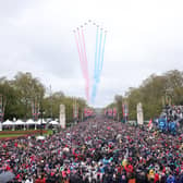 Crowds made their way down the Mall and towards Buckingham Palace, to greet to the new King and Queen at the balcony of Buckingham Palace. Shortly after the royal arrival on the balcony, a traditional Red Arrow flyover - which had been scaled back due to weather - brightened the rainy skies over London. (Credit: Getty Images)