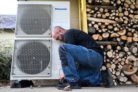 A worker installs a heat pump in a private home in western France. The Government has expanded the Boiler Upgrade Scheme to include air-to-air heat pumps that heat in winter and cool in summer (Photo: DAMIEN MEYER/AFP via Getty Images)