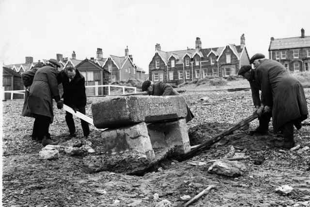 It took a lot of manpower in January 1974 to remove the horse trough, which was a well known landmark on St Annes beach, north of the Pier . Behind stand the wooden beach chalets which have long since gone