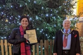 Mayor Ian Titman presents Helen Driver with her award in front of Ampthill's huge Christmas tree