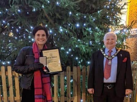 Mayor Ian Titman presents Helen Driver with her award in front of Ampthill's huge Christmas tree