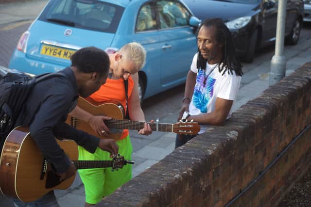 A guitar lesson outside Outreach Music Group