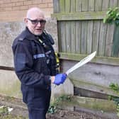 A member of the team holds up the knife found less than 200 metres from a primary school