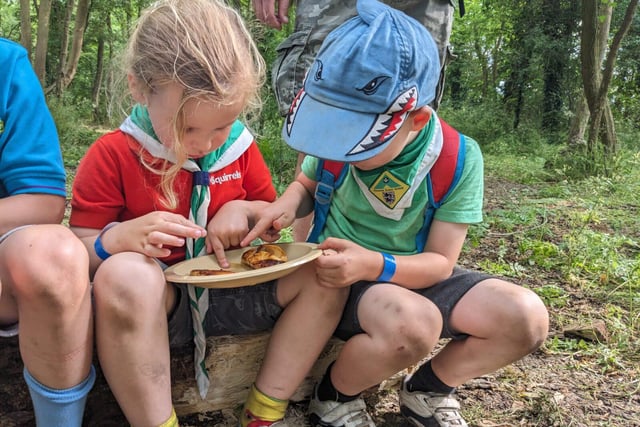 Two Squirrel Scouts share food on a plate