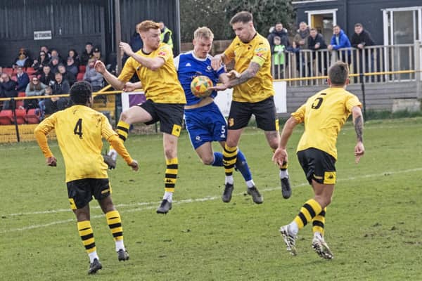 Ben Tompkins fights for possession in the penalty area. Photo: Adrian Brown.