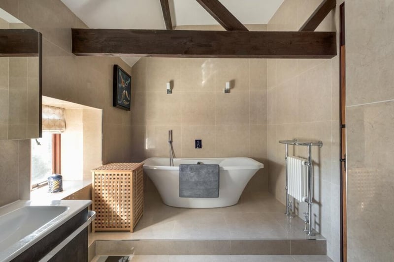 The beamed but contemporary bathroom will have every shower devotee allowing themselves the occasional wallow, too, in the stylish, freestanding bath