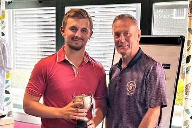 Club champion George Garnham collects his trophy from captain Lloyd Conaway.