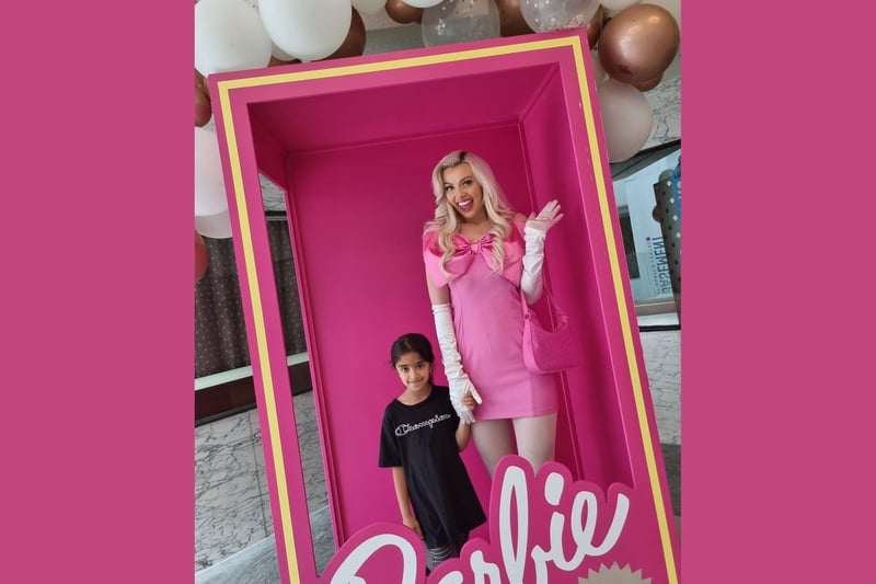 Barbie gives the camera a wave as she's snapped with this young fan.