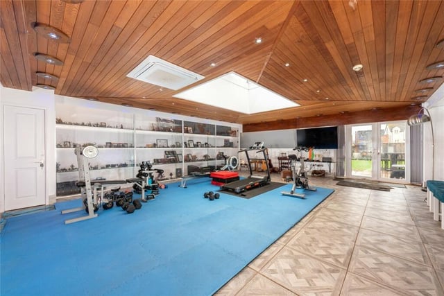 This massive room - measuring 41ft 5in by 24ft 9in - is currently being used as a gym. It has a panelled ceiling with a roof lantern, glazed cabinets, a porcelain tiled floor and glazed double doors to the rear garden