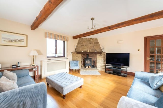 The dual aspect sitting room has French doors to the front garden, a corner fireplace with a log burning stove, and exposed oak flooring