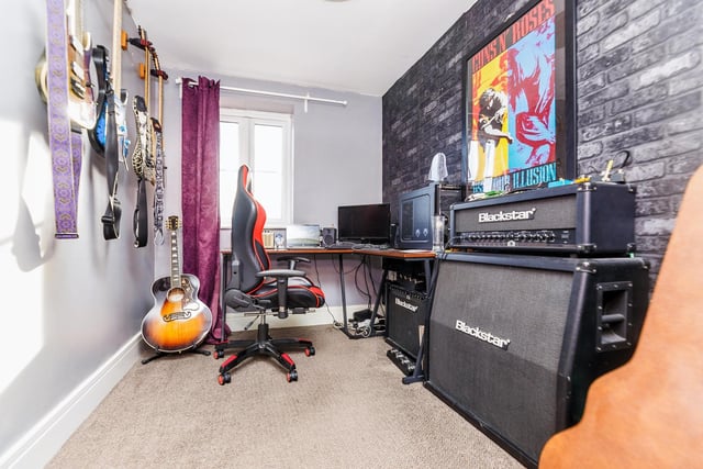 This bedroom is currently a rock fan's dream, housing guitars, an amp and speakers.