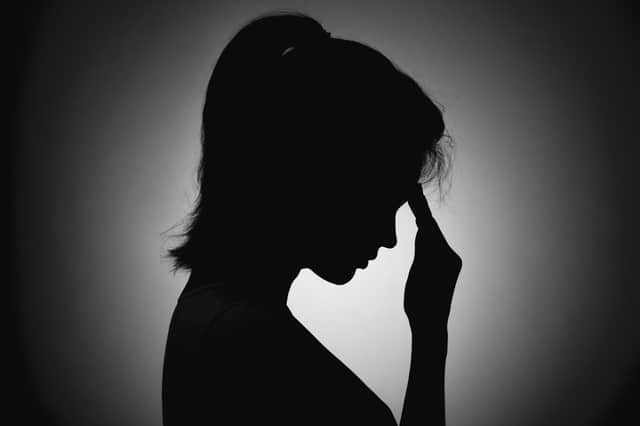 silhouette of the girl face profile of an unrecognizable sad, woman in depression bent her head and put her hand to forehead
