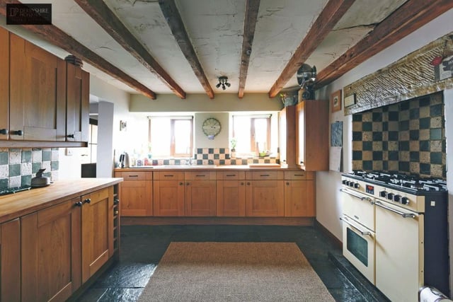 The kitchen contains a large range of fitted oak-fronted wall and base units with wood block surfaces over. An inglenook style recess houses the gas cooking range with two ovens and warming drawer plus six ring gas burner.