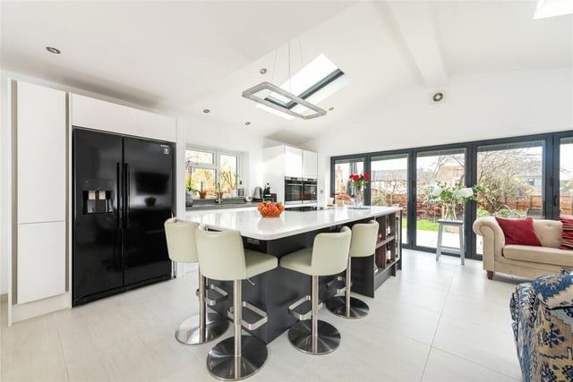 The kitchen has a range of modern units with Quartz work surfaces. The central island has a breakfast bar, an induction hob with extractor over and a wine chiller