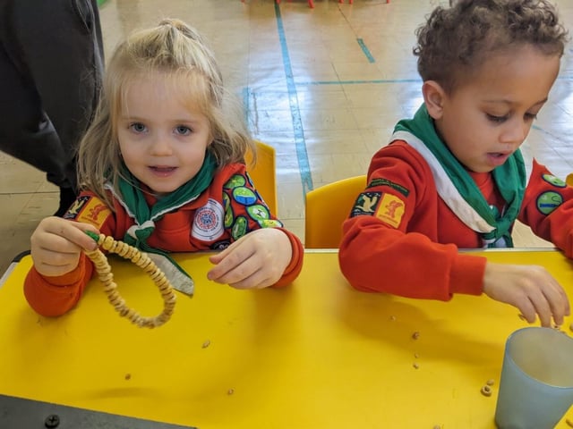 Two Squirrel Scouts making a bird feeder