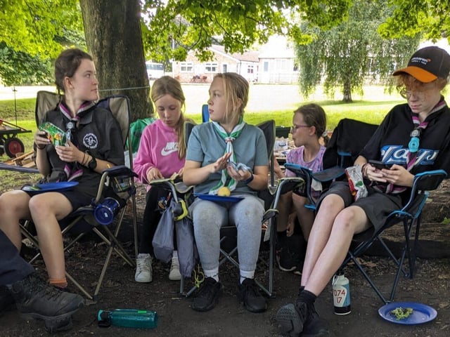 Scouts sit around a small campfire