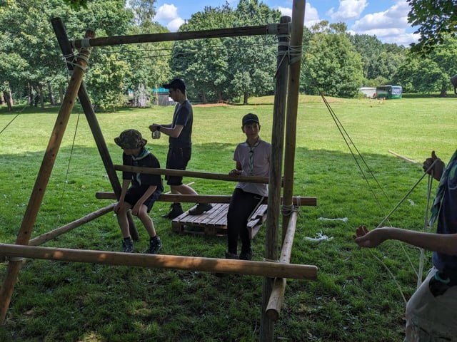 Two Scouts sit on a bench they are in the process of constructing via pioneering