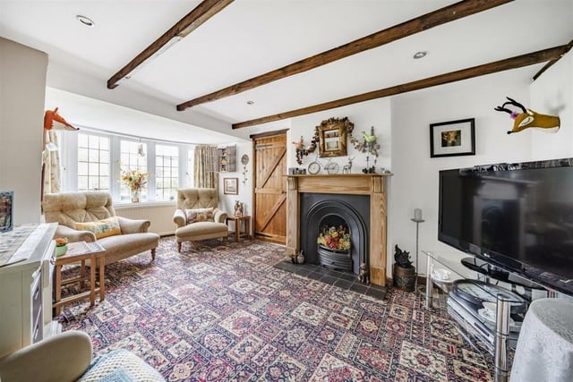 The family room is adjacent to the living room and is a charming space with an open coal fire and beautiful views out of the bay window to the garden