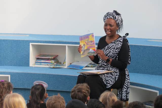 Pilgrims Early Years Practitioner Nuru reading her new book to children at the school