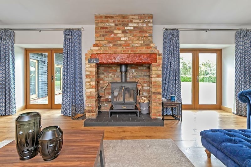 Measuring 30ft 1in by 18ft 2in, this room features two sets of French doors leading on to the rear garden, built-in surround system and a large fireplace with log burning stove