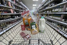 A small selection of essential items sits in a shopping trolley as the cost of living continues to spiral (Photo illustration by Christopher Furlong/Getty Images)