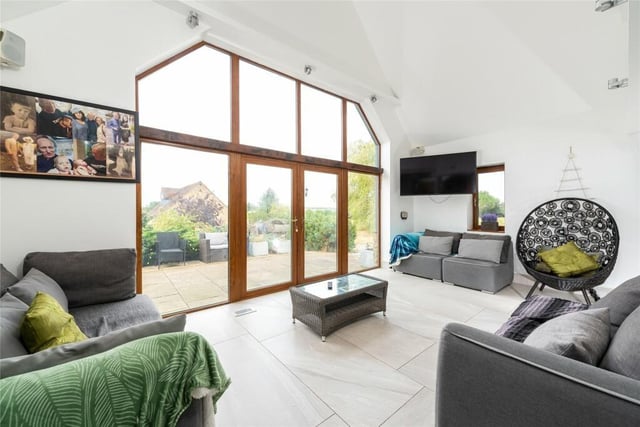 This room is dual aspect with sash windows overlooking the rear courtyard and gardens and has a stone fireplace with a raised hearth and timber bressumer housing a multi-fuel burning stove