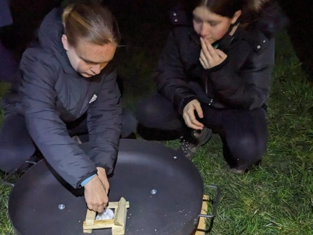 Two Scouts fire lighting.