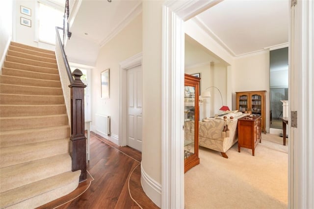 The entrance hall has a high ceiling, a staircase with individual balustrades and exposed wood effect Karndean flooring