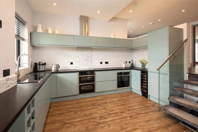 The kitchen is fitted with an extensive range of flush-fitting base and wall units. Integrated appliances include a dishwasher, double oven, microwave, warming drawer, fridge freezer and wine cooler
