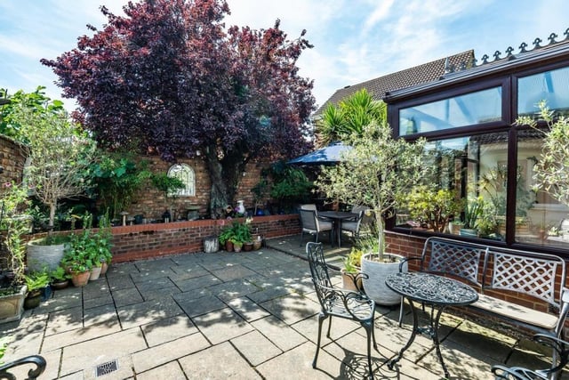 There is a large patio area with brick retaining borders with a variety of shrubs. There are also two outbuildings incorporating an original potting shed and store barn