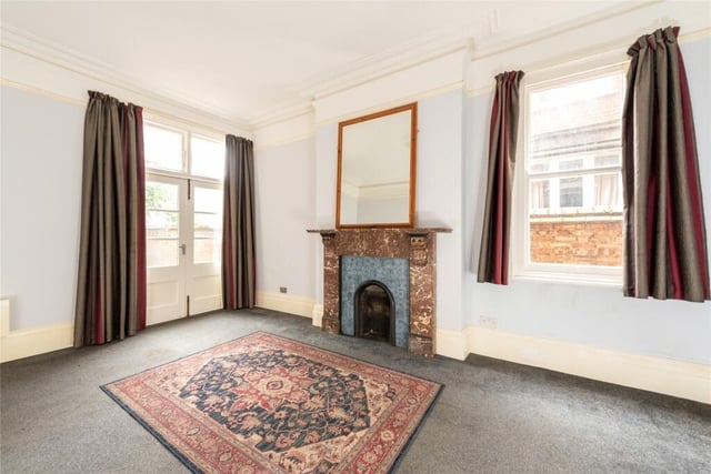 This room also has a feature marble fireplace with an open grate and French doors to the rear