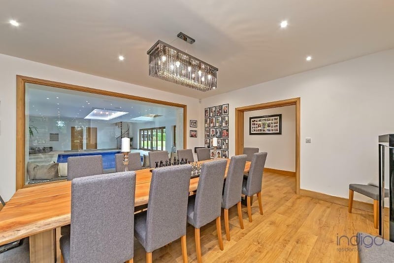 The formal dining room - measuring 16ft 3in by 15ft - features a large glass wall overlooking the indoor swimming pool