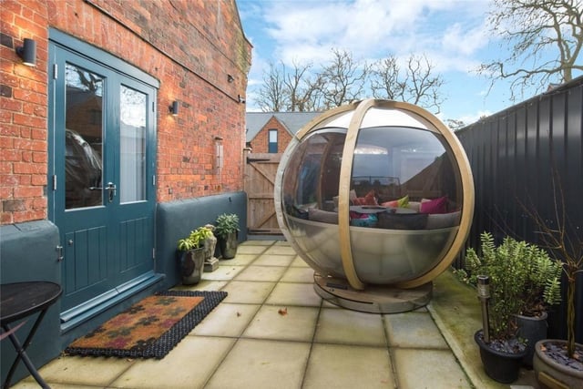 Outside, there is a driveway for three allocated parking spaces and access to a detached single garage via double timber gates. The garden also features this seating pod