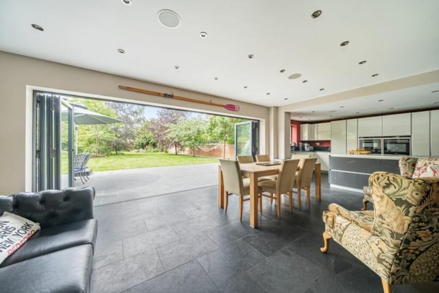 The stunning open plan kitchen/dining/living area with bi-fold doors to the garden