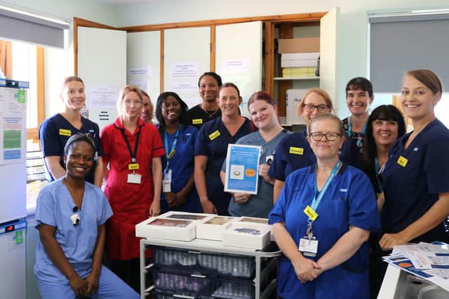 Midwife Fraya stands holds up a ‘Little Nest’ poster, standing alongside fellow staff members and representatives from Bedfordshire Hospitals NHS Charity. Image: Bedfordshire Hospitals NHS Foundation Trust.