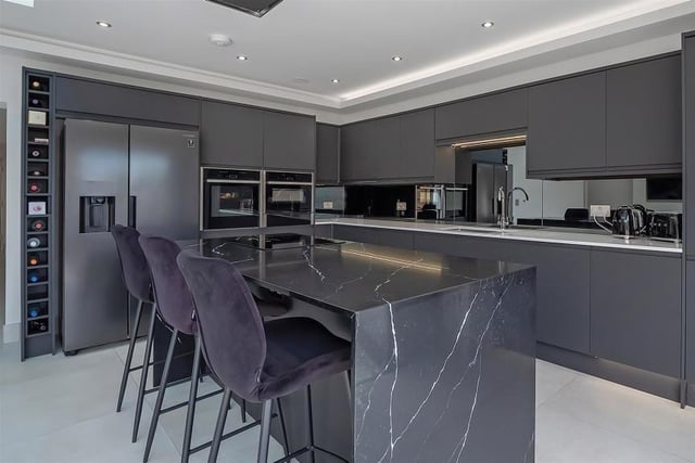 The modern kitchen is fitted with Neff appliances with a large breakfast bar for cooking, eating and entertaining