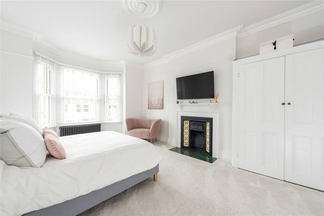 This principal bedroom has a feature fireplace, a built-in double wardrobe, and a refitted en suite shower room