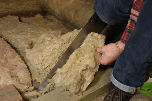File photo of a person laying loft insulation