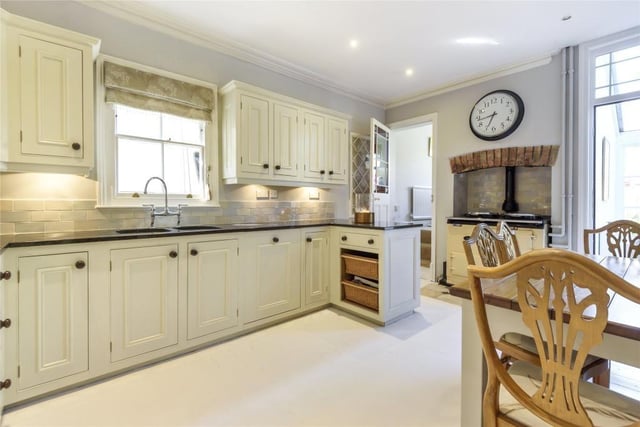 The kitchen is fitted in a bespoke range of hand-painted farmhouse style cabinets with granite work surfaces and a sink and drainer