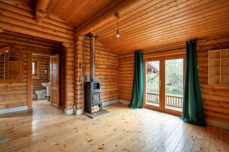 The lounge area has a log fire, and there’s also an air conditioning/heating unit for swift warmth or cooling. French doors give easy access out on to the deck