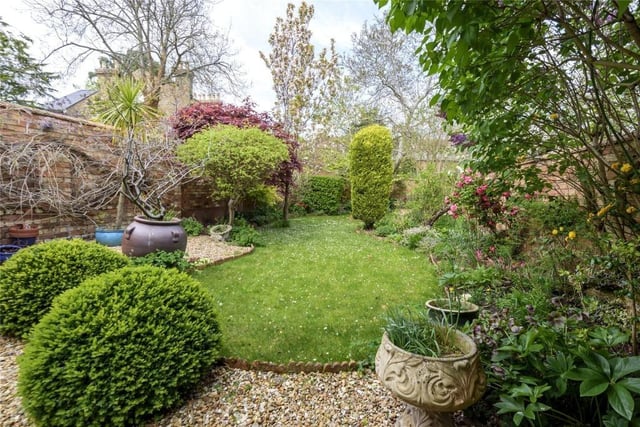 The mature well-maintained garden extends to 70ft and includes upper and lower graveled seating areas, a central lawn, well-stocked borders and mature trees