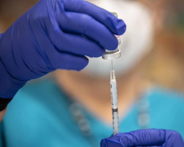 A nurse fills up a syringe with the Moderna COVID-19 vaccine. Photo by Sergio Flores/Getty Images