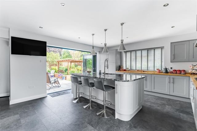 This room features a range of modern kitchen units and integrated appliances, an island/breakfast bar with a granite top and ample space for a breakfast table/seating area. The kitchen/breakfast room also boasts a further set of bi-fold doors to the rear garden