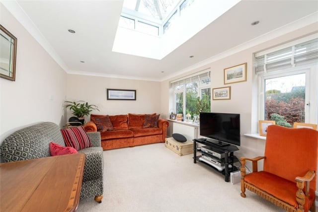 This room features a glass sky lantern, and windows and doors with views of the rear garden