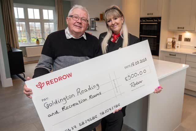 Gerard McAuley, secretary and trustee of the Goldington Reading Rooms in Bedford accepts the £500 cheque from Redrow Homes sales consultant Debbie Johnson