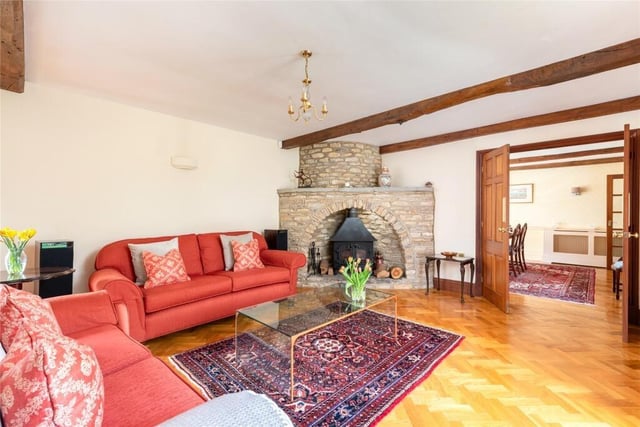 This room is dual aspect with French doors opening to the formal garden at the front and rear of the property. It also has a feature stone fireplace in one corner with an inset log burning stove on a raised hearth