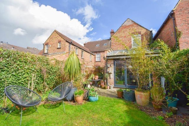 The property has a landscaped rear garden with a patio and lawn area, perfect for those summer barbecues