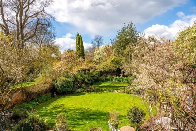 There are two circular lawned areas with well-stocked borders and mature trees including fruit trees. Additionally, there is a timber garden shed