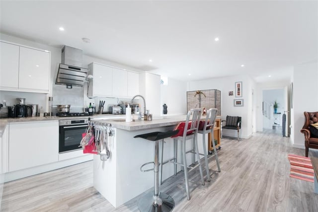 The kitchen has a range of white high gloss units, including a central island which incorporates a breakfast bar. There are complementary work surfaces and integrated appliances. The room measures 29ft 5in by 18ft 1in