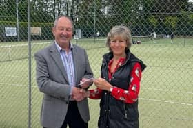 Head coach Terry Mabbitt presents Sally Olney with the charity proceeds